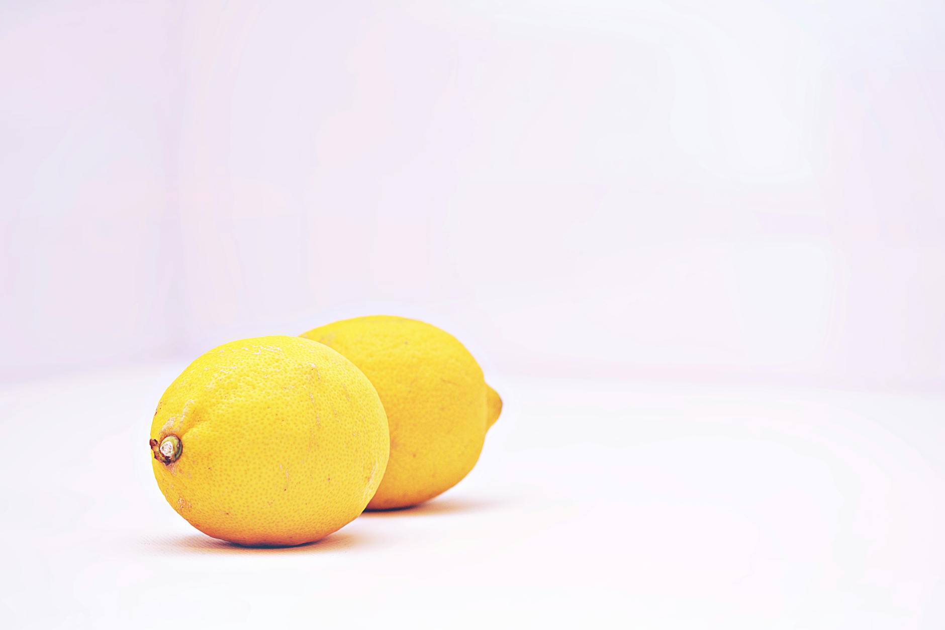 Pink lemon vibrator on purple background with heart confetti and candles for romance